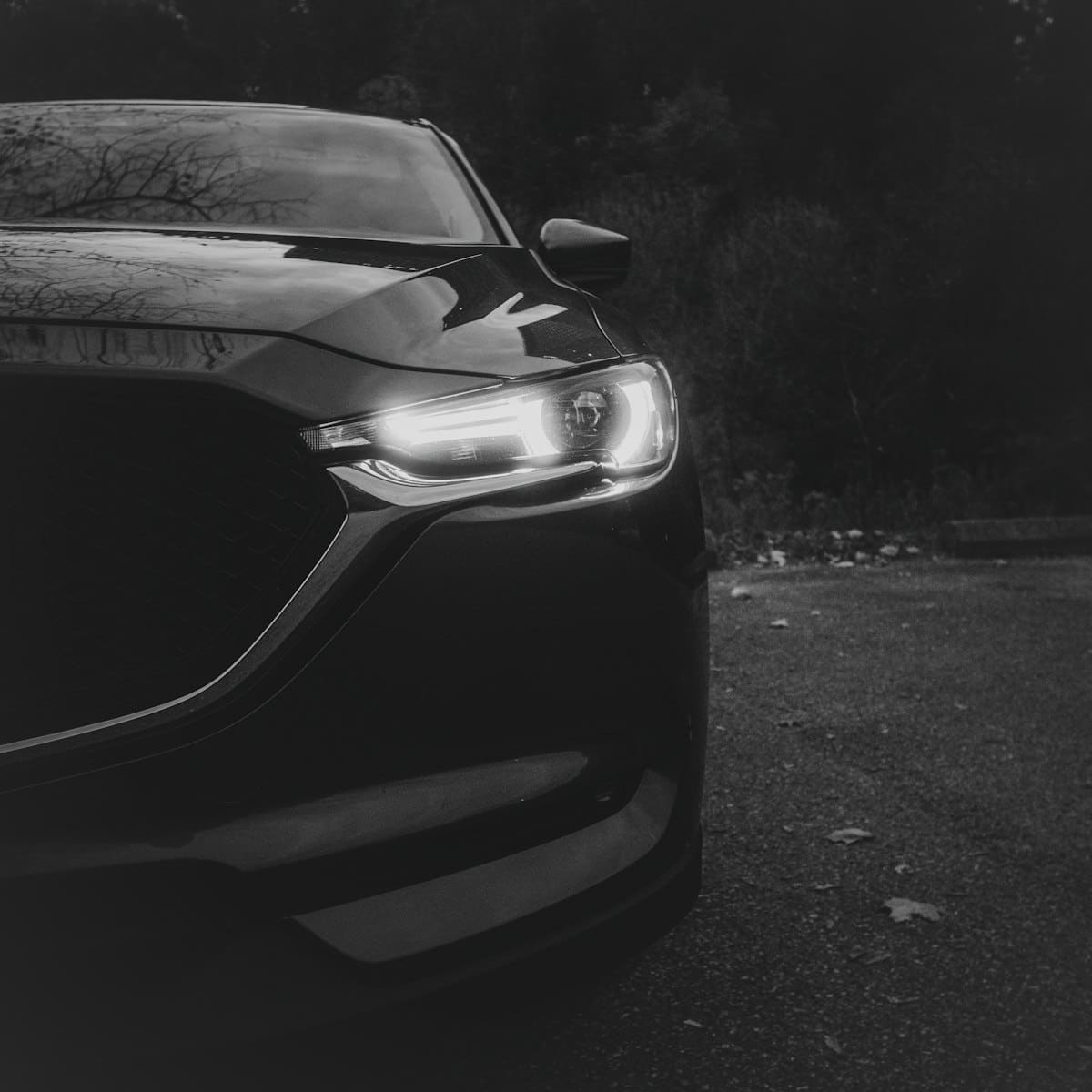 Sfeerbeeld van een donkere auto met verlichte koplamp